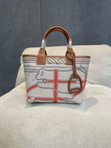 Steeple 25 Bag. Authentic quality luxury bag crafted in genuine leather comes with authenticity card, dust bag and gift bag. Where art meets heritage. The *rmès Steeple Bag is a charming fusion of heritage and artistry, crafted from a blend of canvas and Swift leather. Its design pays tribute to *rmès’ equestrian roots with whip-shaped handles and a stirrup-inspired charm, adding a playful yet sophisticated touch. Lightweight yet spacious, the Steeple is ideal for daily use. Whether you opt for a vibrant motif or a sleek, single-color design, this bag stands out as an artistic expression of luxury that seamlessly integrates into a modern lifestyle. Praised for its unique aesthetic and accessibility within the *rmès lineup, the Steeple Bag is adored by fashion enthusiasts who appreciate its colorful palette and bold personality. While it’s best suited for those who enjoy the texture and look of canvas, it remains a versatile statement piece that captures the spirit of everyday elegance. - CRIS&COCO Steeple 25 Bag. Authentic quality luxury bag crafted in genuine leather comes with authenticity card, dust bag and gift bag. Where art meets heritage. The *rmès Steeple Bag is a charming fusion of heritage and artistry, crafted from a blend of canvas and Swift leather. Its design pays tribute to *rmès’ equestrian roots with whip-shaped handles and a stirrup-inspired charm, adding a playful yet sophisticated touch. Lightweight yet spacious, the Steeple is ideal for daily use. Whether you opt for a vibrant motif or a sleek, single-color design, this bag stands out as an artistic expression of luxury that seamlessly integrates into a modern lifestyle. Praised for its unique aesthetic and accessibility within the *rmès lineup, the Steeple Bag is adored by fashion enthusiasts who appreciate its colorful palette and bold personality. While it’s best suited for those who enjoy the texture and look of canvas, it remains a versatile statement piece that captures the spirit of everyday elegance.