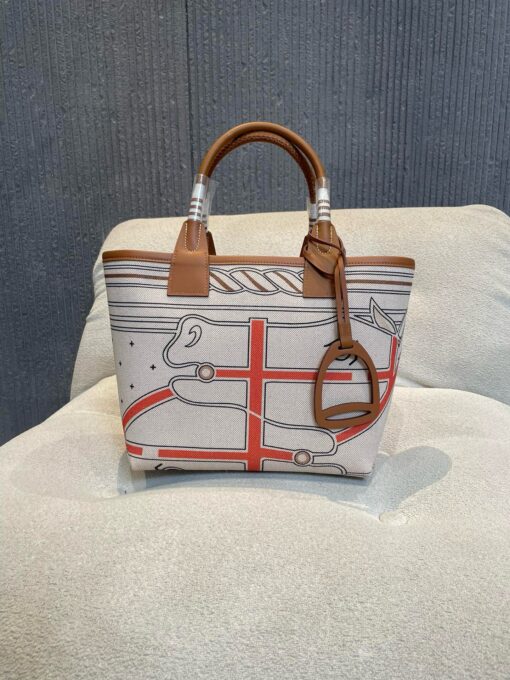 Steeple 25 Bag. Authentic quality luxury bag crafted in genuine leather comes with authenticity card, dust bag and gift bag. Where art meets heritage. The *rmès Steeple Bag is a charming fusion of heritage and artistry, crafted from a blend of canvas and Swift leather. Its design pays tribute to *rmès’ equestrian roots with whip-shaped handles and a stirrup-inspired charm, adding a playful yet sophisticated touch. Lightweight yet spacious, the Steeple is ideal for daily use. Whether you opt for a vibrant motif or a sleek, single-color design, this bag stands out as an artistic expression of luxury that seamlessly integrates into a modern lifestyle. Praised for its unique aesthetic and accessibility within the *rmès lineup, the Steeple Bag is adored by fashion enthusiasts who appreciate its colorful palette and bold personality. While it’s best suited for those who enjoy the texture and look of canvas, it remains a versatile statement piece that captures the spirit of everyday elegance.