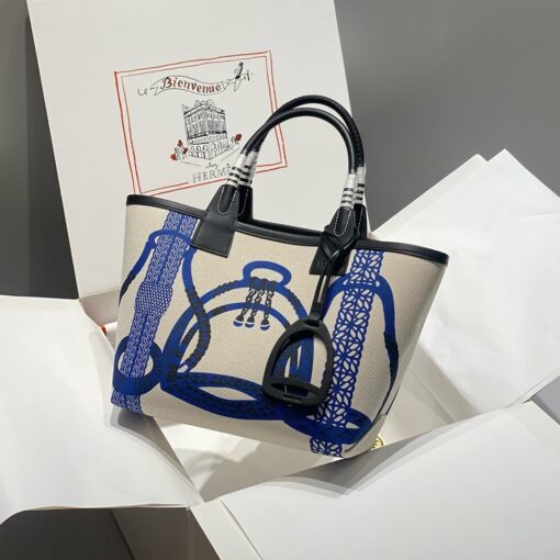 Steeple 25 Bag. Authentic quality luxury bag crafted in genuine leather comes with authenticity card, dust bag and gift bag. Where art meets heritage. The *rmès Steeple Bag is a charming fusion of heritage and artistry, crafted from a blend of canvas and Swift leather. Its design pays tribute to *rmès’ equestrian roots with whip-shaped handles and a stirrup-inspired charm, adding a playful yet sophisticated touch. Lightweight yet spacious, the Steeple is ideal for daily use. Whether you opt for a vibrant motif or a sleek, single-color design, this bag stands out as an artistic expression of luxury that seamlessly integrates into a modern lifestyle. Praised for its unique aesthetic and accessibility within the *rmès lineup, the Steeple Bag is adored by fashion enthusiasts who appreciate its colorful palette and bold personality. While it’s best suited for those who enjoy the texture and look of canvas, it remains a versatile statement piece that captures the spirit of everyday elegance.