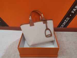 Steeple 25 Bag. Authentic quality luxury bag crafted in genuine leather comes with authenticity card, dust bag and gift bag. Where art meets heritage. The *rmès Steeple Bag is a charming fusion of heritage and artistry, crafted from a blend of canvas and Swift leather. Its design pays tribute to *rmès’ equestrian roots with whip-shaped handles and a stirrup-inspired charm, adding a playful yet sophisticated touch. Lightweight yet spacious, the Steeple is ideal for daily use. Whether you opt for a vibrant motif or a sleek, single-color design, this bag stands out as an artistic expression of luxury that seamlessly integrates into a modern lifestyle. Praised for its unique aesthetic and accessibility within the *rmès lineup, the Steeple Bag is adored by fashion enthusiasts who appreciate its colorful palette and bold personality. While it’s best suited for those who enjoy the texture and look of canvas, it remains a versatile statement piece that captures the spirit of everyday elegance. - CRIS&COCO Steeple 25 Bag. Authentic quality luxury bag crafted in genuine leather comes with authenticity card, dust bag and gift bag. Where art meets heritage. The *rmès Steeple Bag is a charming fusion of heritage and artistry, crafted from a blend of canvas and Swift leather. Its design pays tribute to *rmès’ equestrian roots with whip-shaped handles and a stirrup-inspired charm, adding a playful yet sophisticated touch. Lightweight yet spacious, the Steeple is ideal for daily use. Whether you opt for a vibrant motif or a sleek, single-color design, this bag stands out as an artistic expression of luxury that seamlessly integrates into a modern lifestyle. Praised for its unique aesthetic and accessibility within the *rmès lineup, the Steeple Bag is adored by fashion enthusiasts who appreciate its colorful palette and bold personality. While it’s best suited for those who enjoy the texture and look of canvas, it remains a versatile statement piece that captures the spirit of everyday elegance.