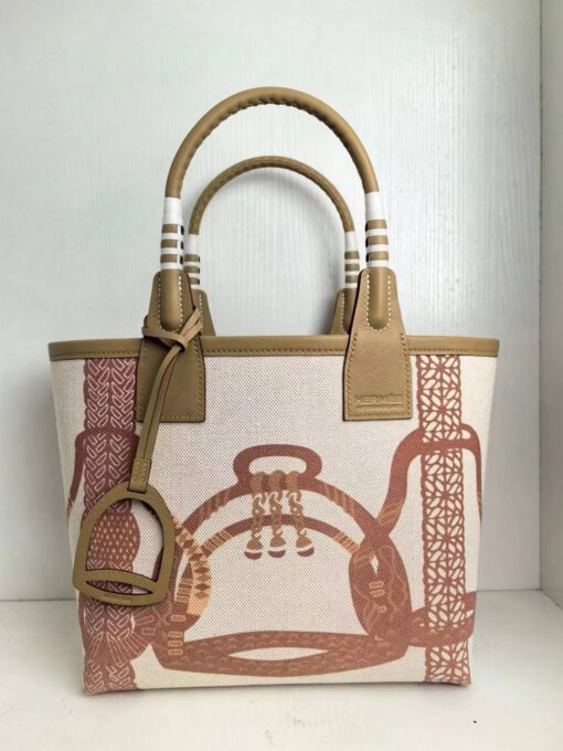 Steeple 25 Bag. Authentic quality luxury bag crafted in genuine leather comes with authenticity card, dust bag and gift bag. Where art meets heritage. The *rmès Steeple Bag is a charming fusion of heritage and artistry, crafted from a blend of canvas and Swift leather. Its design pays tribute to *rmès’ equestrian roots with whip-shaped handles and a stirrup-inspired charm, adding a playful yet sophisticated touch. Lightweight yet spacious, the Steeple is ideal for daily use. Whether you opt for a vibrant motif or a sleek, single-color design, this bag stands out as an artistic expression of luxury that seamlessly integrates into a modern lifestyle. Praised for its unique aesthetic and accessibility within the *rmès lineup, the Steeple Bag is adored by fashion enthusiasts who appreciate its colorful palette and bold personality. While it’s best suited for those who enjoy the texture and look of canvas, it remains a versatile statement piece that captures the spirit of everyday elegance.