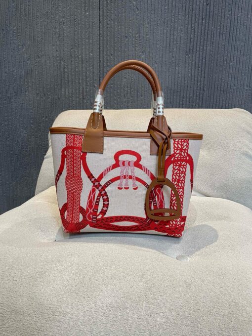 Steeple 25 Bag. Authentic quality luxury bag crafted in genuine leather comes with authenticity card, dust bag and gift bag. Where art meets heritage. The *rmès Steeple Bag is a charming fusion of heritage and artistry, crafted from a blend of canvas and Swift leather. Its design pays tribute to *rmès’ equestrian roots with whip-shaped handles and a stirrup-inspired charm, adding a playful yet sophisticated touch. Lightweight yet spacious, the Steeple is ideal for daily use. Whether you opt for a vibrant motif or a sleek, single-color design, this bag stands out as an artistic expression of luxury that seamlessly integrates into a modern lifestyle. Praised for its unique aesthetic and accessibility within the *rmès lineup, the Steeple Bag is adored by fashion enthusiasts who appreciate its colorful palette and bold personality. While it’s best suited for those who enjoy the texture and look of canvas, it remains a versatile statement piece that captures the spirit of everyday elegance.