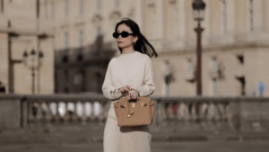 Woman in oversized sunglasses walking in SoHo with pastel Hermès-style bag