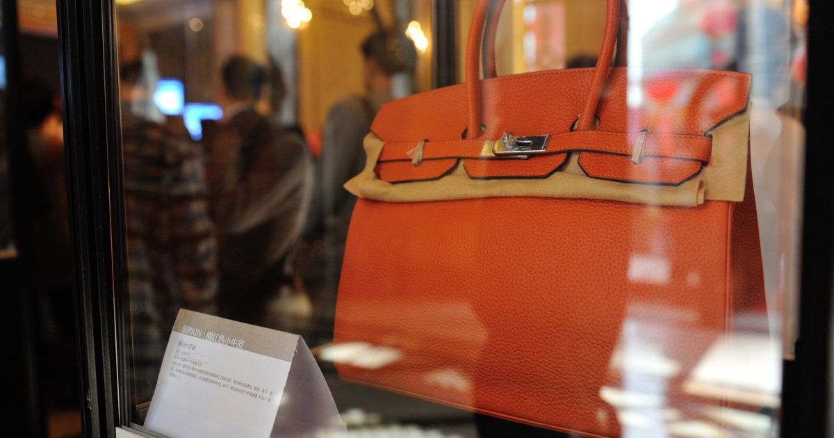 Woman on subway with bright orange replica BIRKIN and oversized sunglasses Woman on subway with bright orange replica BIRKIN and oversized sunglasses