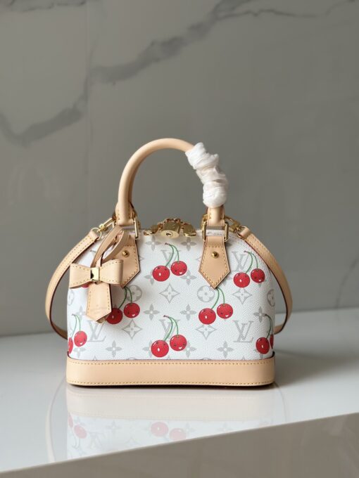 LV x TM Alma BB. Authentic quality luxury bag crafted in genuine leather comes with authenticity card, dust bag and gift bag. A Joyful Icon Reimagined. Playful, artistic, and instantly iconic—the Alma BB returns in a joyful re-edition as part of the celebrated LV x TM collection. This petite masterpiece blends the timeless Art Deco-inspired silhouette with Takashi Murakami’s signature whimsy, splashing the House’s Monogram canvas with bold, cherry-bright motifs. Crafted with natural leather accents and finished with polished gold-tone hardware, it features structured Toron top handles and a charming bow-shaped keybell that adds just the right amount of flirt. Compact yet attention-commanding, the Alma BB is a true collectible—full of joy, color, and unmistakable LV heritage. Carry art. Wear happiness. Make a statement.