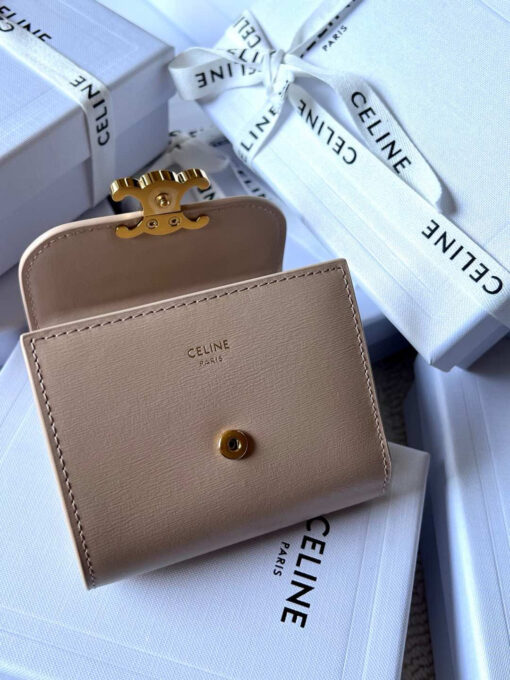 Small Flap Wallet Triomphe. Authentic quality luxury bag crafted in genuine leather comes with authenticity card, dust bag and gift bag. Small in Size, Grand in Style. Discover timeless sophistication in the palm of your hand with the *ELINE Small Flap Wallet TRIOMPHE in shiny calfskin. Meticulously crafted from luxurious leather, this compact beauty showcases the iconic Triomphe clasp in gold-tone metal, a refined nod to Parisian heritage. Despite its petite size, it opens to reveal smart compartments for cards, bills, and coins—proving that style never compromises function. Whether tucked into your favorite designer bag or carried solo for a night out, this wallet is your everyday dose of quiet luxury.