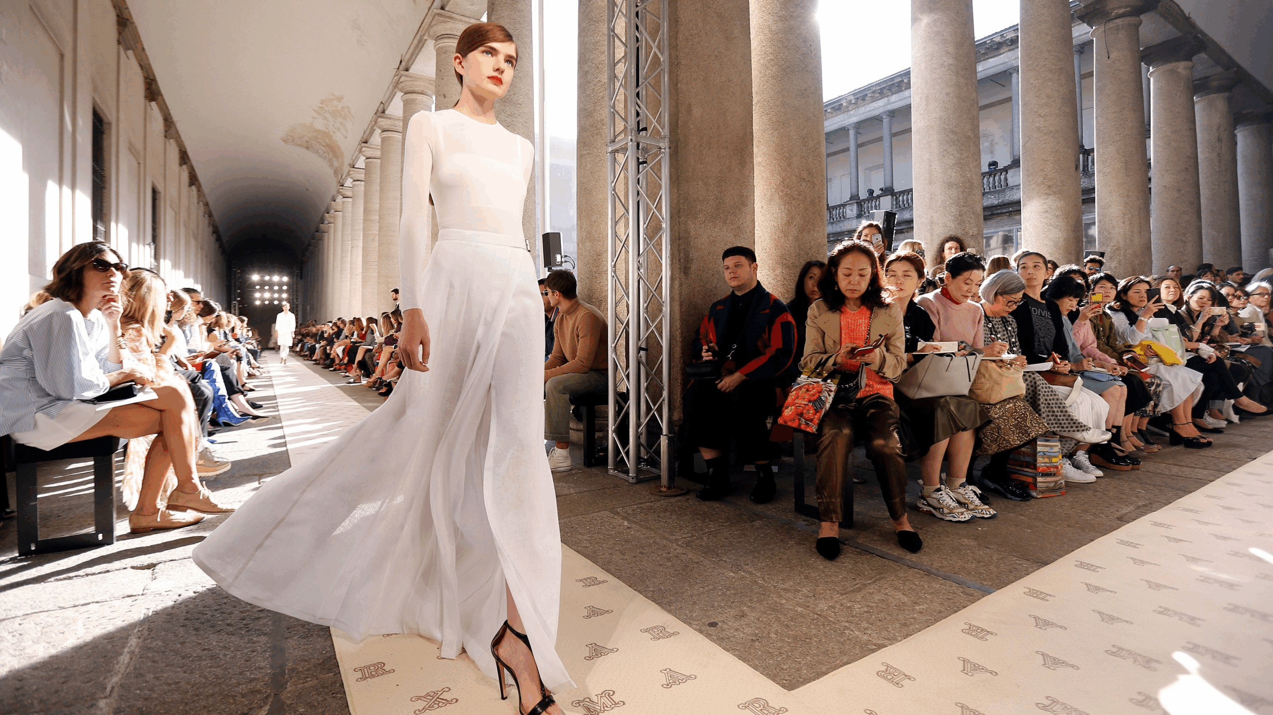 Spotlights and silk on the runway. But who pays the price for luxury?