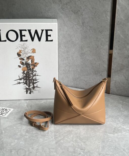 Puzzle Fold Pouch. Authentic quality luxury bag crafted in genuine leather comes with authenticity card, dust bag and gift bag. Sculpted Sophistication — The Art of Function. The Puzzle Fold Pouch redefines modern elegance with its sculptural geometry and effortless versatility. Crafted in luxurious shiny nappa calfskin, its signature folded panels create a dynamic, architectural silhouette that’s instantly recognizable. Both stylish and practical, this pouch transitions seamlessly from day to night—perfect for carrying essentials with a touch of *OEWE sophistication. A masterpiece of craftsmanship, it’s the ultimate blend of innovation and timeless design.