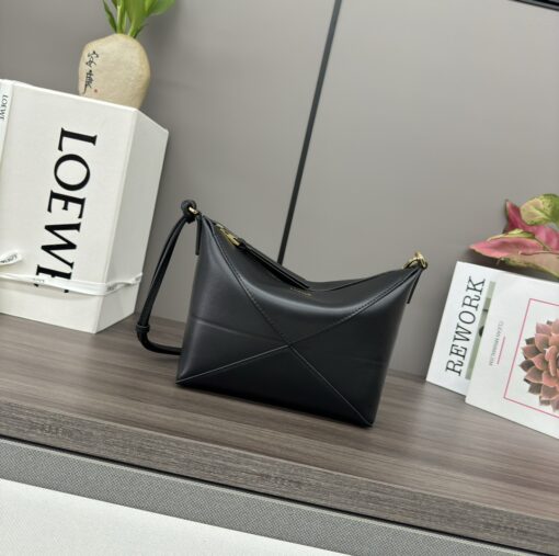 Puzzle Fold Pouch. Authentic quality luxury bag crafted in genuine leather comes with authenticity card, dust bag and gift bag. Sculpted Sophistication — The Art of Function. The Puzzle Fold Pouch redefines modern elegance with its sculptural geometry and effortless versatility. Crafted in luxurious shiny nappa calfskin, its signature folded panels create a dynamic, architectural silhouette that’s instantly recognizable. Both stylish and practical, this pouch transitions seamlessly from day to night—perfect for carrying essentials with a touch of *OEWE sophistication. A masterpiece of craftsmanship, it’s the ultimate blend of innovation and timeless design.