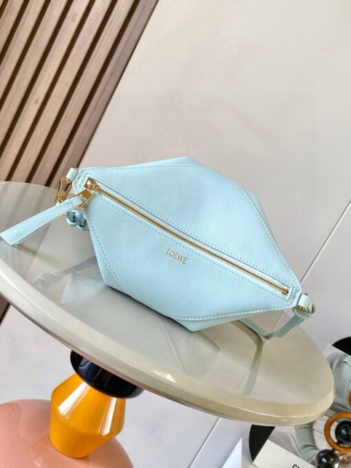 Puzzle Fold Pouch. Authentic quality luxury bag crafted in genuine leather comes with authenticity card, dust bag and gift bag. Sculpted Sophistication — The Art of Function. The Puzzle Fold Pouch redefines modern elegance with its sculptural geometry and effortless versatility. Crafted in luxurious shiny nappa calfskin, its signature folded panels create a dynamic, architectural silhouette that’s instantly recognizable. Both stylish and practical, this pouch transitions seamlessly from day to night—perfect for carrying essentials with a touch of *OEWE sophistication. A masterpiece of craftsmanship, it’s the ultimate blend of innovation and timeless design.