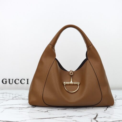 Softbit Maxi Shoulder Bag. Authentic quality luxury bag crafted in genuine leather comes with authenticity card, dust bag and gift bag. Icon Reimagined: Effortless Luxury with a Modern Bit of Bold. *ucci’s timeless heritage meets contemporary ease in the new Softbit Shoulder Bag. Crafted from supple grained leather with a luxuriously rich texture, this piece balances sophistication and function effortlessly. At its heart lies an oversized half-horsebit — a bold reinterpretation of the House’s iconic detail — accenting the magnetic closure with statement appeal. With its relaxed silhouette and refined craftsmanship, the Softbit is the perfect companion for those who favor effortless elegance with a modern edge.