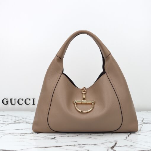 Softbit Maxi Shoulder Bag. Authentic quality luxury bag crafted in genuine leather comes with authenticity card, dust bag and gift bag. Icon Reimagined: Effortless Luxury with a Modern Bit of Bold. *ucci’s timeless heritage meets contemporary ease in the new Softbit Shoulder Bag. Crafted from supple grained leather with a luxuriously rich texture, this piece balances sophistication and function effortlessly. At its heart lies an oversized half-horsebit — a bold reinterpretation of the House’s iconic detail — accenting the magnetic closure with statement appeal. With its relaxed silhouette and refined craftsmanship, the Softbit is the perfect companion for those who favor effortless elegance with a modern edge.