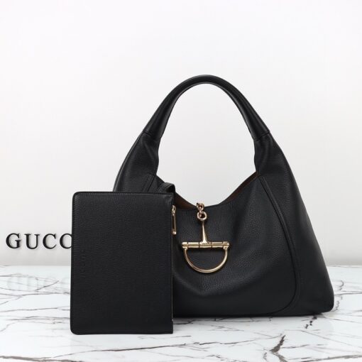 Softbit Maxi Shoulder Bag. Authentic quality luxury bag crafted in genuine leather comes with authenticity card, dust bag and gift bag. Icon Reimagined: Effortless Luxury with a Modern Bit of Bold. *ucci’s timeless heritage meets contemporary ease in the new Softbit Shoulder Bag. Crafted from supple grained leather with a luxuriously rich texture, this piece balances sophistication and function effortlessly. At its heart lies an oversized half-horsebit — a bold reinterpretation of the House’s iconic detail — accenting the magnetic closure with statement appeal. With its relaxed silhouette and refined craftsmanship, the Softbit is the perfect companion for those who favor effortless elegance with a modern edge.